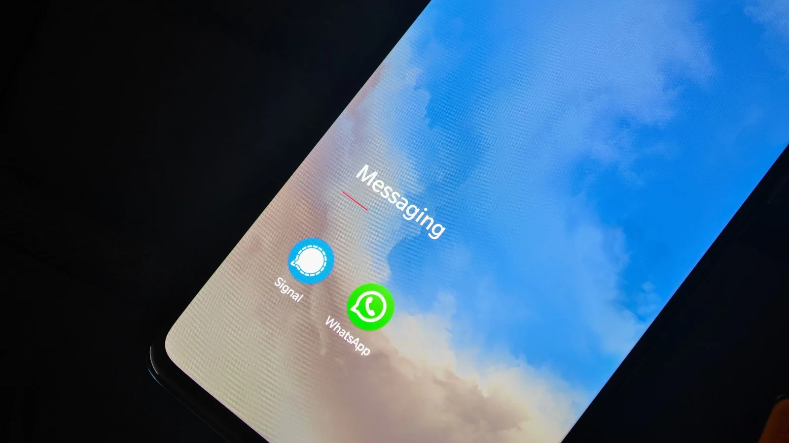 A smartphone screen showing the WhatsApp and Signal messaging app icons