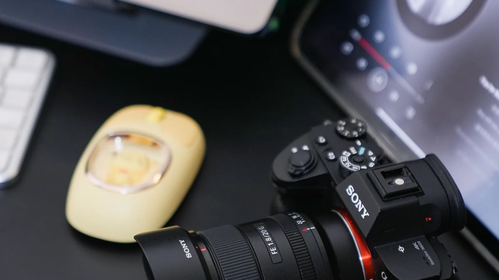 A digital camera beside a laptop in a photographer's workspace, representing EXIF and other photo metadata