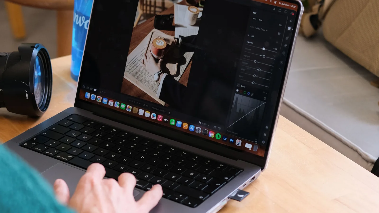 A camera beside a laptop used to check image metadata while editing a photo