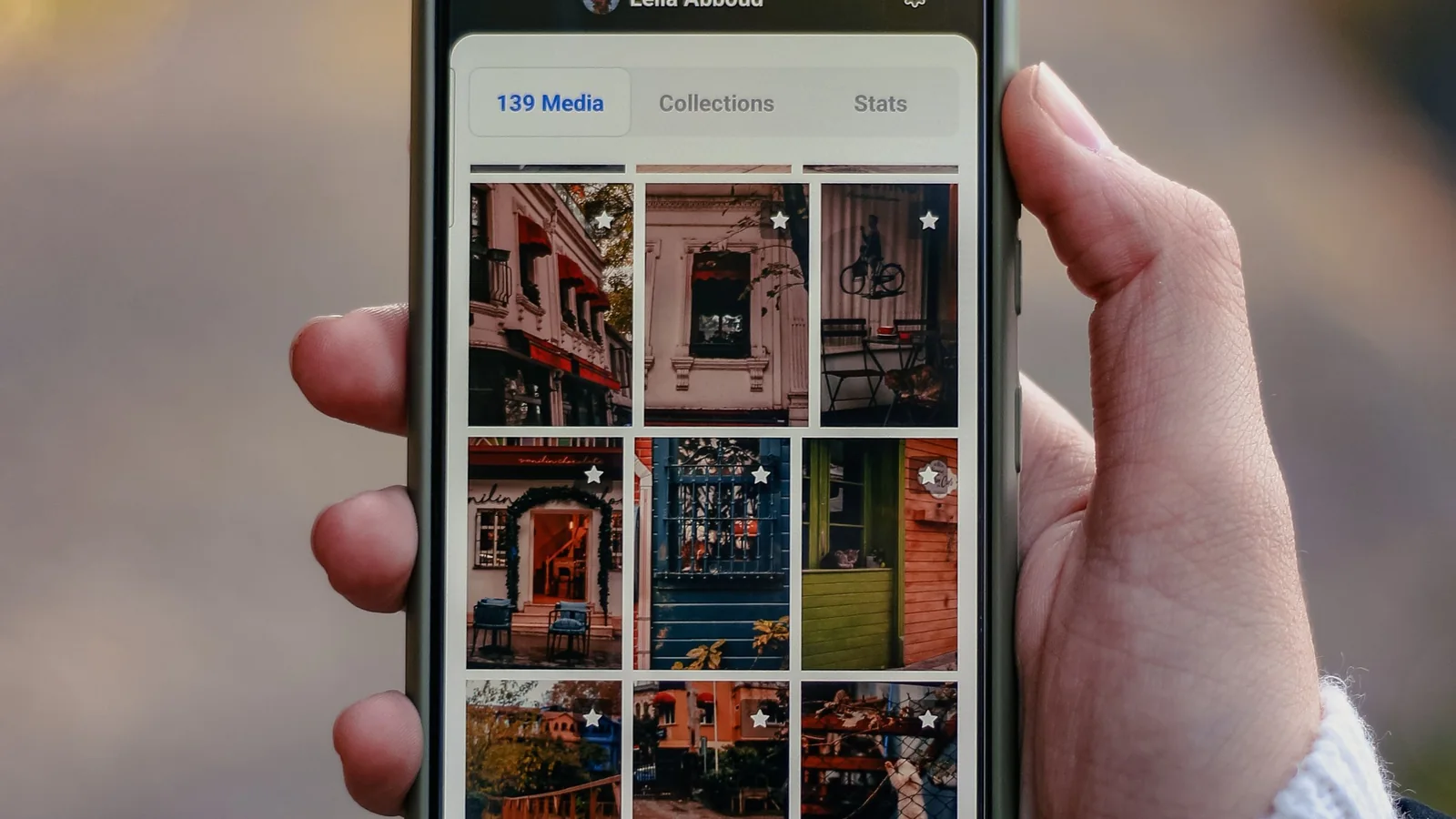 A person holding a smartphone and browsing a gallery of photos before checking the images for EXIF data