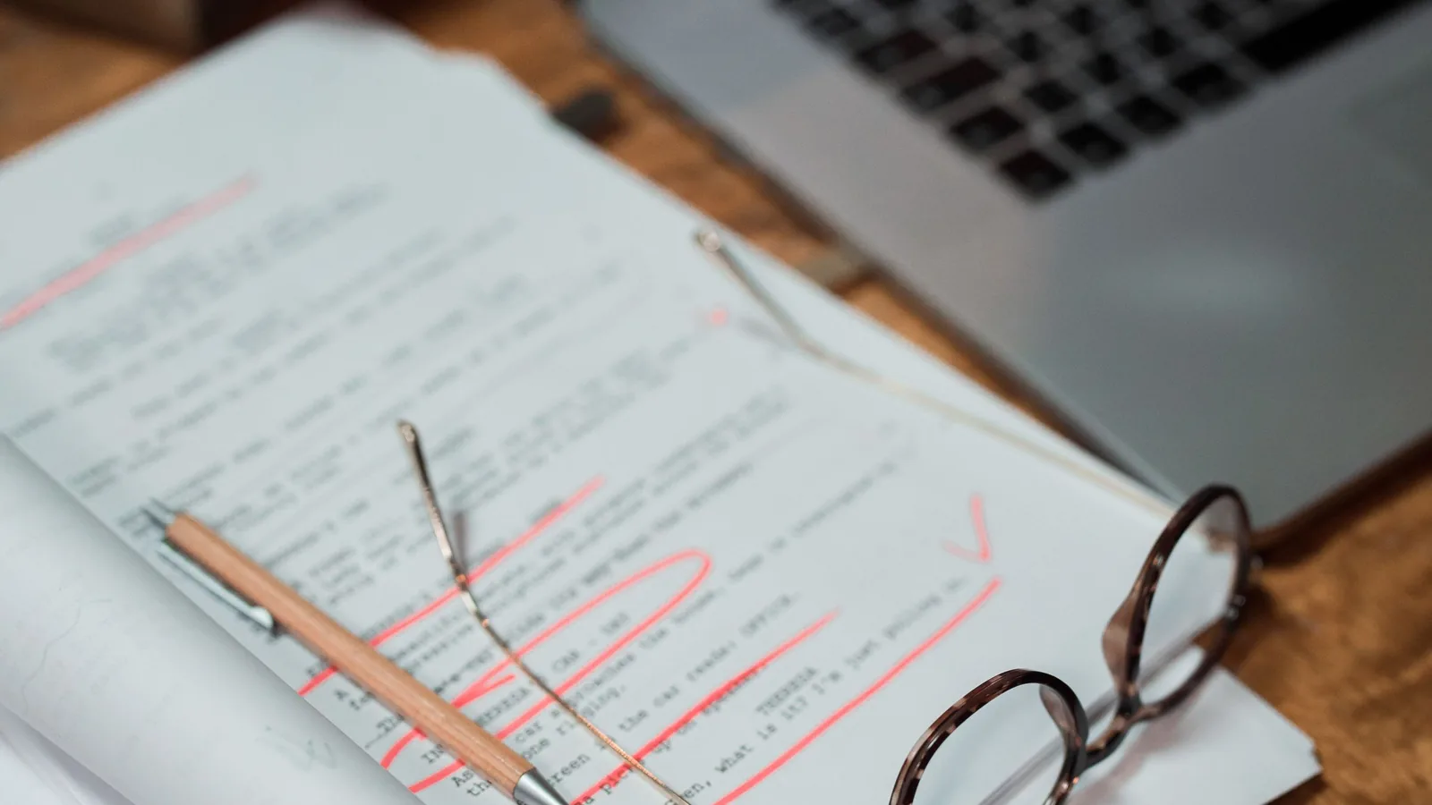 Glasses resting on printed documents beside a laptop while checking PDF metadata and file properties