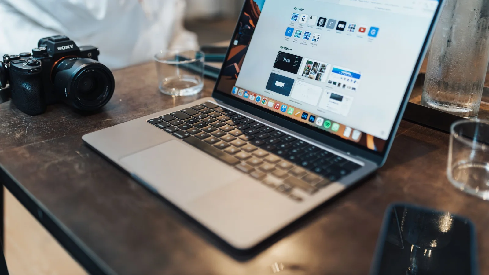 A MacBook beside a camera for checking photo metadata on Mac
