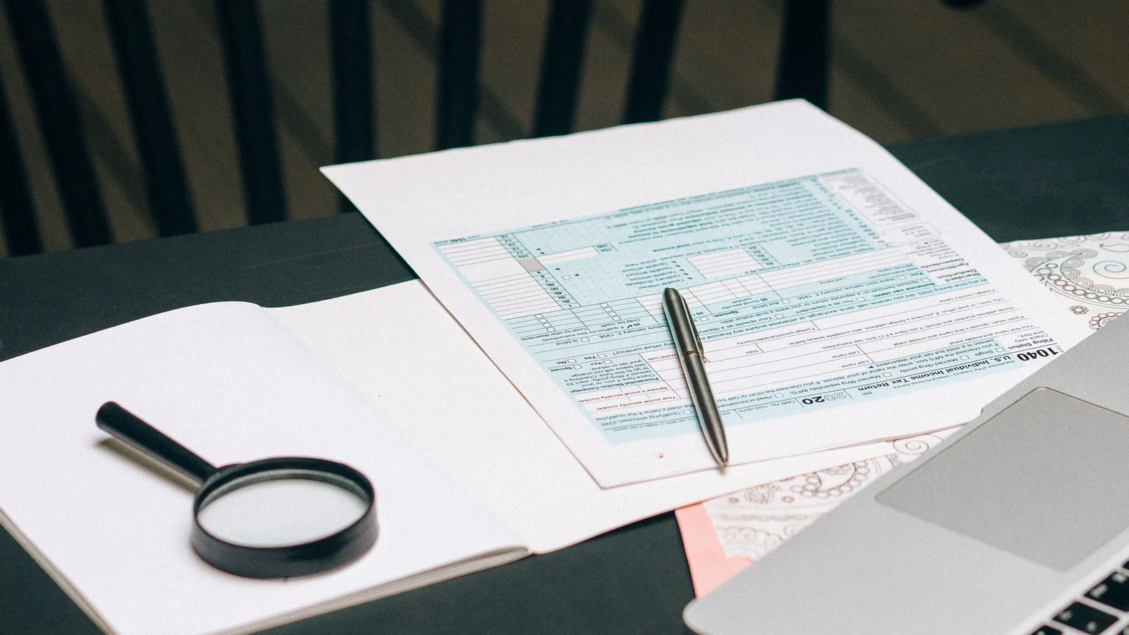Documents, a magnifying glass and a laptop prepared for removing metadata from a Word document